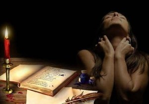 mujer+sola+trsite+preocupada+escribiendo+libro+vela+